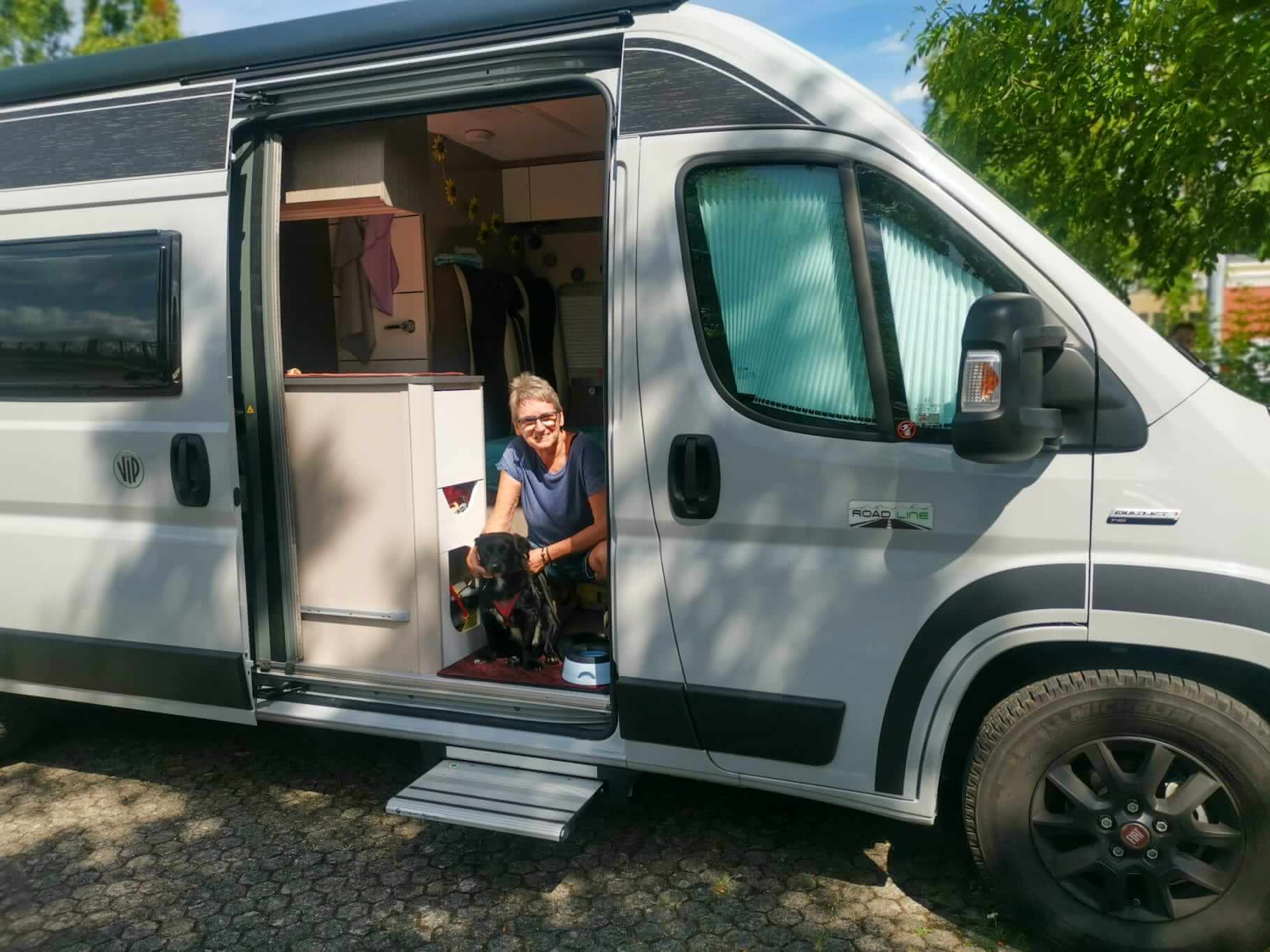 Camper und Hund schaut zur Türe raus mit Frauchen