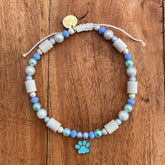 EM-Keramikhalsband mit blauen Perlen und goldenem Anhänger mit blauer Pfote